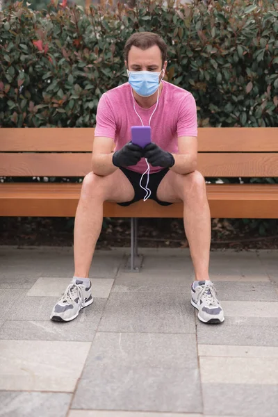 Sportman Met Medisch Masker Handschoenen Smartphone Oordopjes Aan Het Trainen — Stockfoto