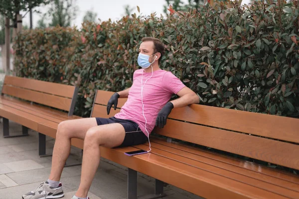 Sportman Met Medisch Masker Handschoenen Smartphone Oordopjes Aan Het Trainen — Stockfoto