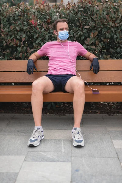 Sportman Met Medisch Masker Handschoenen Smartphone Oordopjes Aan Het Trainen — Stockfoto