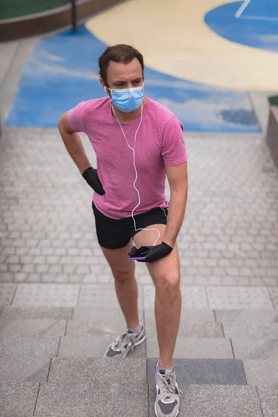 Sportman Met Medisch Masker Handschoenen Smartphone Oordopjes Aan Het Trainen — Stockfoto