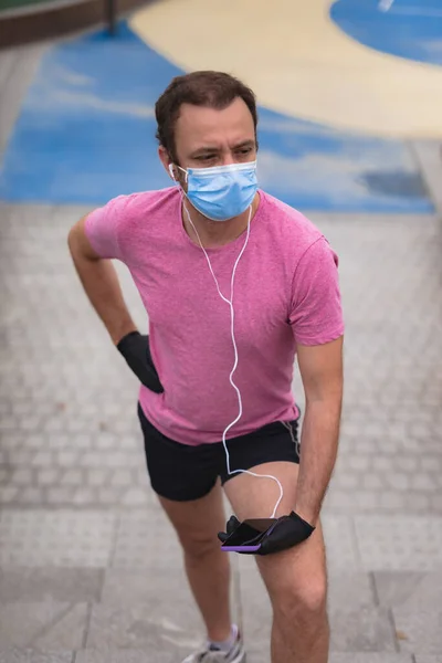 Sportman Met Medisch Masker Handschoenen Smartphone Oordopjes Aan Het Trainen — Stockfoto