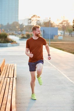 Modern genç adam şehir parkında çalışıyor..