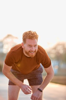 Modern genç adam şehir parkında çalışıyor..