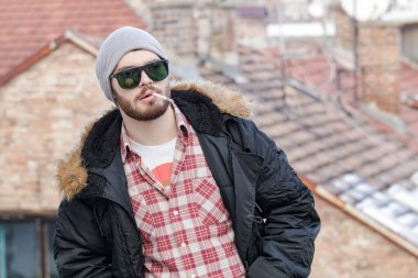 Sokakta sigara içen genç bir adam..