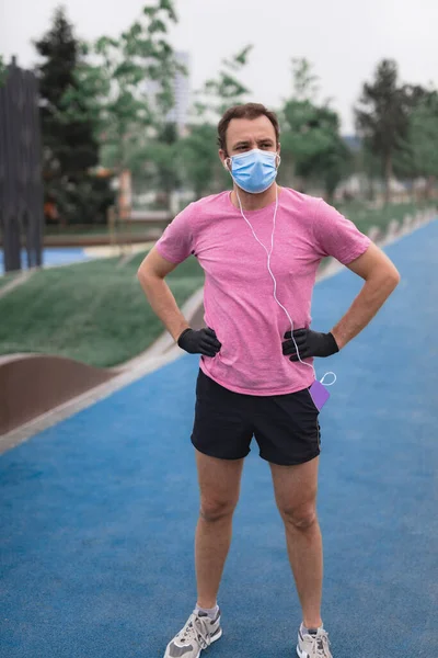 Sportovec Lékařskou Maskou Rukavicemi Smartphone Sluchátka Cvičení Běhání Městském Prostředí — Stock fotografie