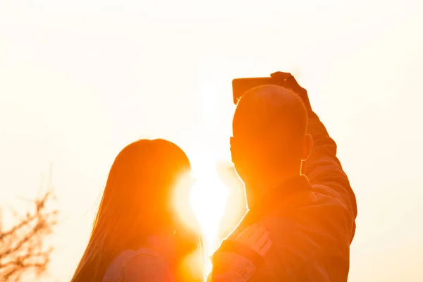 都会の環境でスマートタブレットを使用している若い観光客のカップルは 日の出の時間で写真を撮る — ストック写真