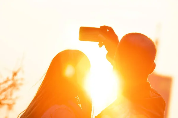 在城市环境中使用智能平板电脑在日落 日出时拍照的年轻夫妇 — 图库照片