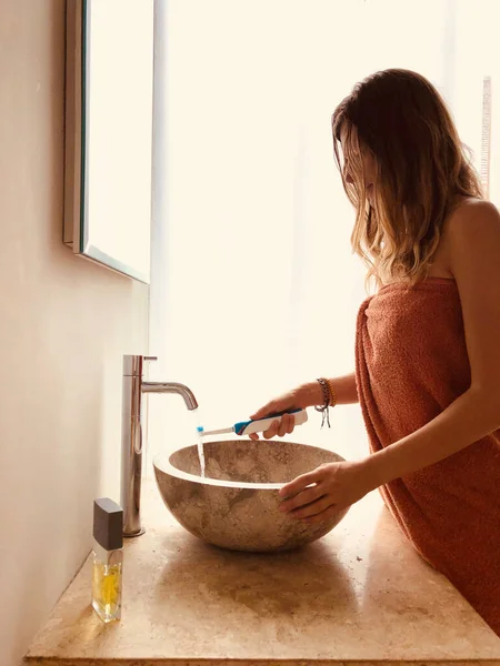 Mujer Usando Cepillo Dientes Baño Iluminado — Foto de Stock