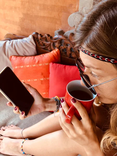 Mujer Joven Moderna Usando Teléfono Celular Tomando Café Sofá Terraza — Foto de Stock