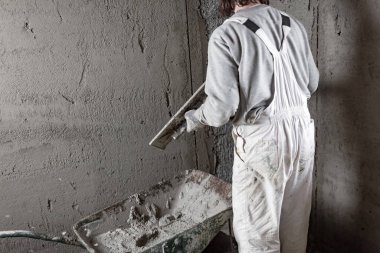 Gerçek inşaat işçisi yeni evin içinde bir duvar yapma.