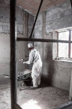 Gerçek inşaat işçisi yeni evin içinde bir duvar yapma.