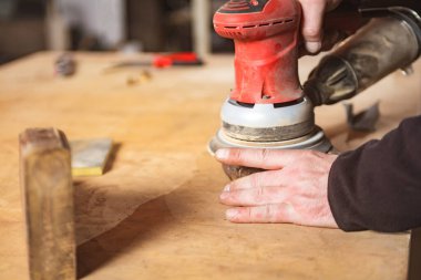 Erkek marangoz antika bir atölyede eski ahşap üzerinde çalışıyor..