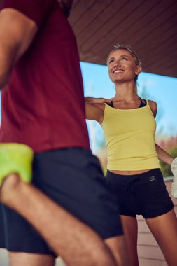 Nehir kenarındaki kentsel çevrede koşan / egzersiz yapan modern kadın ve erkek.