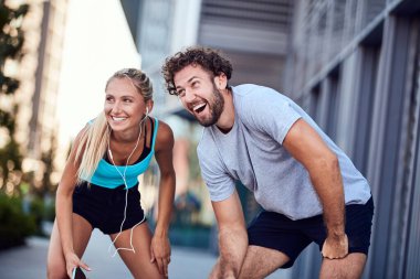 Modern çift koşu / egzersiz sırasında kaldırımda mola veriyor.