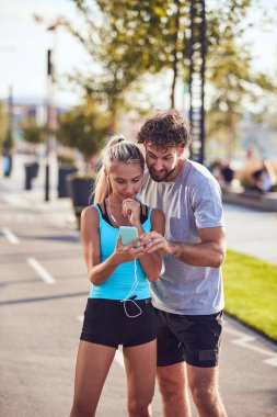 Modern çift koşu / egzersiz sırasında kaldırımda mola veriyor.