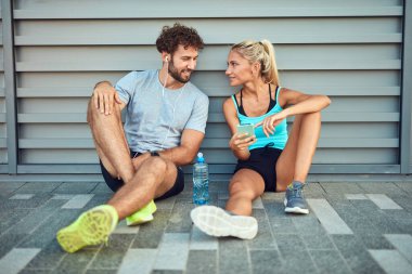 Modern çift koşu / egzersiz sırasında kaldırımda mola veriyor.