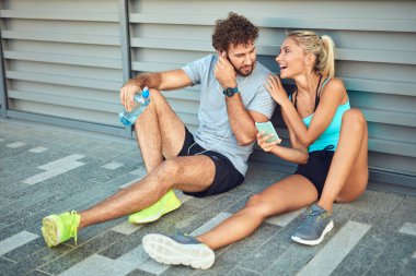 Modern çift koşu / egzersiz sırasında kaldırımda mola veriyor.