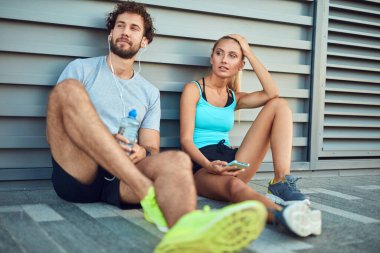 Modern çift koşu / egzersiz sırasında kaldırımda mola veriyor.