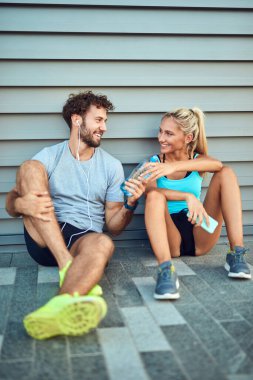 Modern çift koşu / egzersiz sırasında kaldırımda mola veriyor.