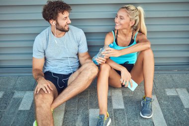Modern çift koşu / egzersiz sırasında kaldırımda mola veriyor.