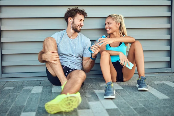 Modern çift koşu / egzersiz sırasında kaldırımda mola veriyor.