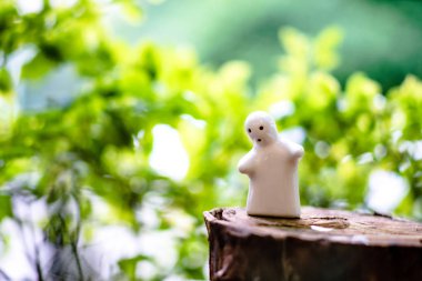 Beyaz seramik bebek Doğal yeşil arka plan ve boke karşı