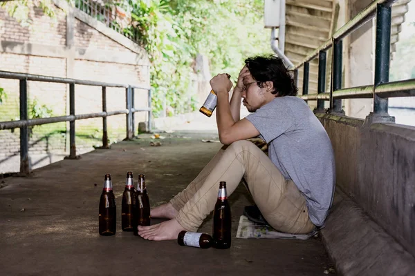 Portret De man dronk droevig drank onder de brug.. — Stockfoto