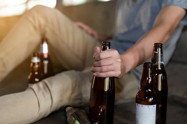 Retrato de un borracho sosteniendo una botella frente a él — Foto de Stock