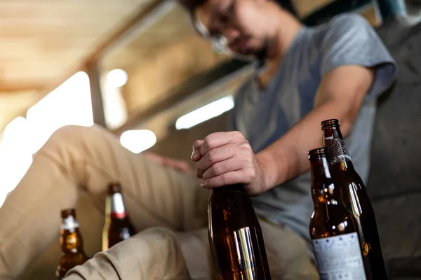 Retrato de un borracho sosteniendo una botella frente a él — Foto de Stock