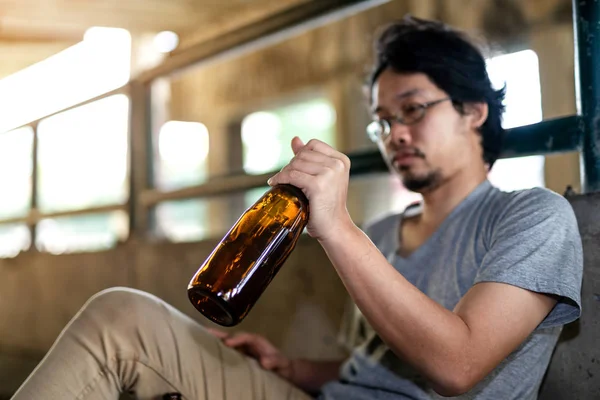 Portré egy részeg emberről, aki egy üveget tart maga előtt. — Stock Fotó