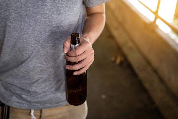 Portrait of a drunken man holding a bottle in front of him — Stock Photo, Image