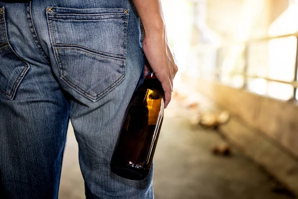 La espalda de un hombre con una botella de licor — Foto de Stock