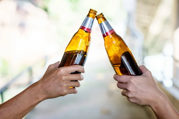 Portrét Druhá ruka drží láhev s alkoholem. — Stock fotografie