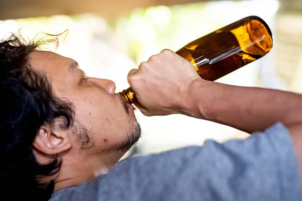 Portret Een dronken man pakt een fles om te drinken. — Stockfoto