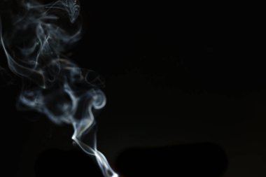 Tütsüden çıkan soyut duman ve siyah arka plandaki ışık