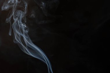 Tütsüden çıkan soyut duman ve siyah arka plandaki ışık