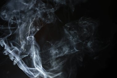 Tütsüden çıkan soyut duman ve siyah arka plandaki ışık