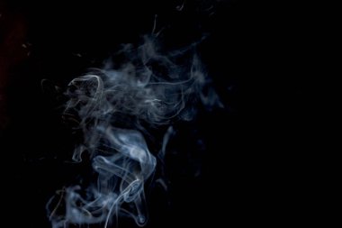 Tütsüden çıkan soyut duman ve siyah arka plandaki ışık