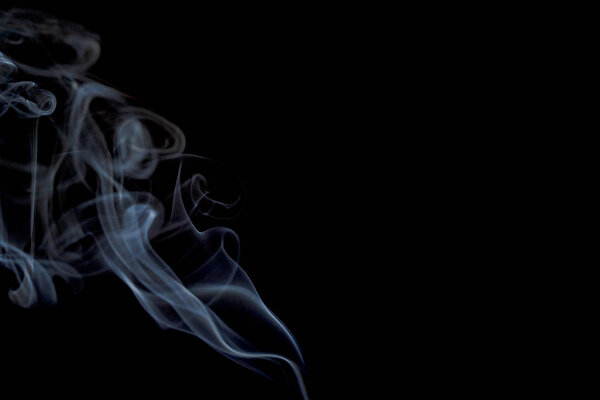 Abstract smoke from incense and light in a black background