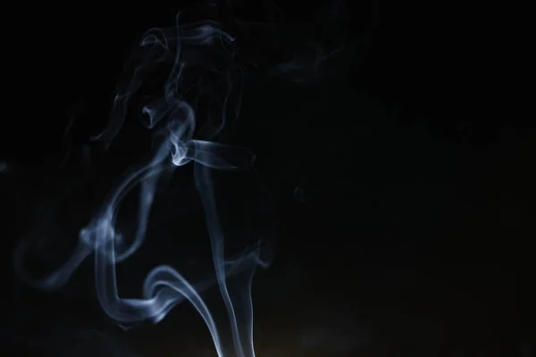 Fumo astratto da incenso e luce su sfondo nero — Foto Stock