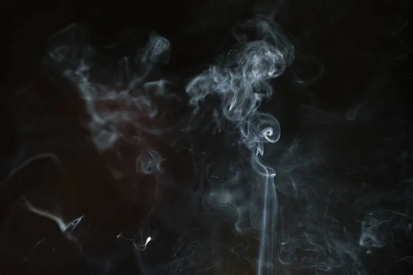 Fumaça abstrata de incenso e luz em um fundo preto — Fotografia de Stock