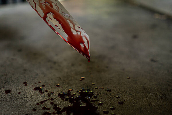 Крупный план ножа с пятнами крови и капающим на пол
.