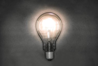 Gece arkaplanında ışık yayan bir ampul görüntüsü