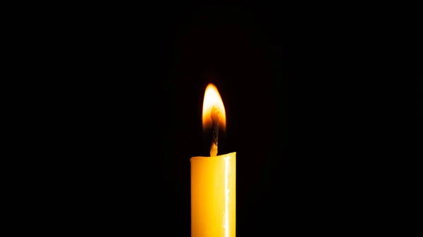 在黑色背景下照亮的黄色蜡烛的特写 — 图库照片