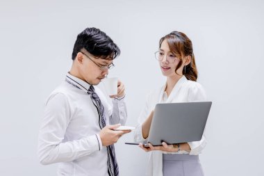 Dizüstü bilgisayara bakıp ofiste çalışan iki şirketin portresi. Genç iş arkadaşları ofiste iş konuşuyorlar..