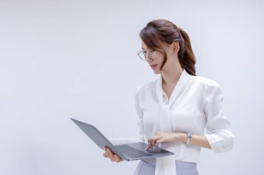 İş portresi dizüstü bilgisayara bakıyor ve ofiste çalışıyor. Genç iş arkadaşları ofiste iş konuşuyorlar..