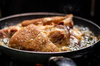 Kızartma tavasında domuz eti pişirirken yakın plan çekimde sıcak yağ var ve lezzetli görünüyor..