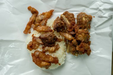 Paket kağıdında kızartılmış domuz pirinci ile yakın plan bir çekim nefis görünüyor..