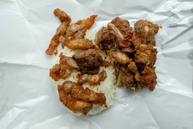 Paket kağıdında kızartılmış domuz pirinci ile yakın plan bir çekim nefis görünüyor..