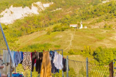 tepelerin önünde kurumaya asılı giysiler